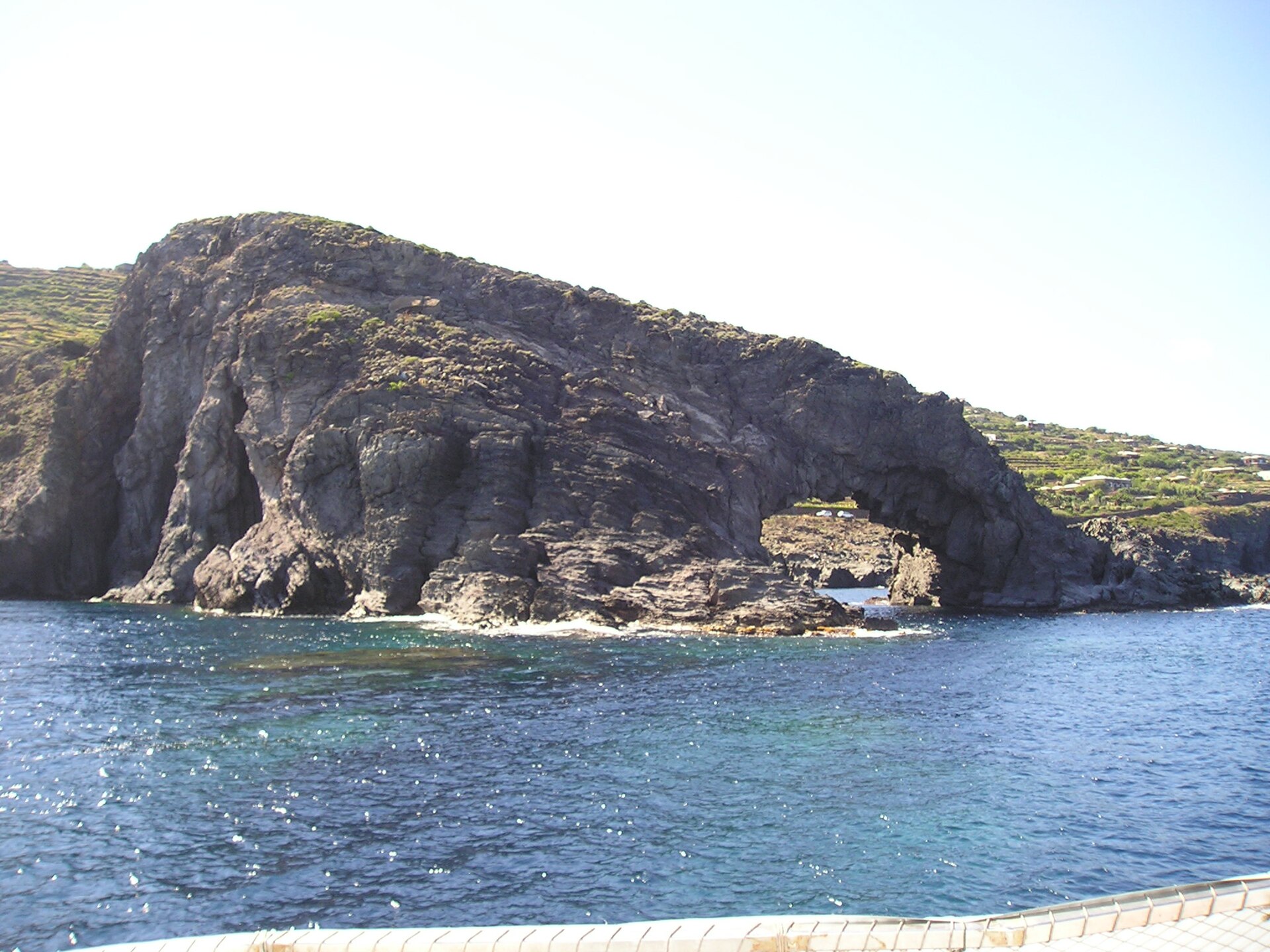 The Arco dell’Elefante lava arch dipping into a turquoise cove on Pantelleria’s east coast