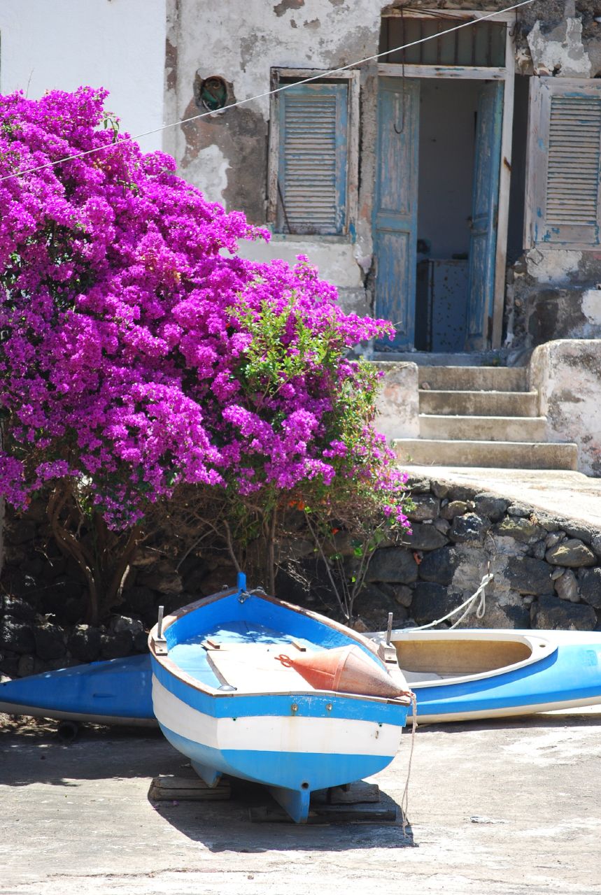 Fishing boats and bougainvillea at Cala Gadir, home to Pantelleria's seaside thermal rock pools