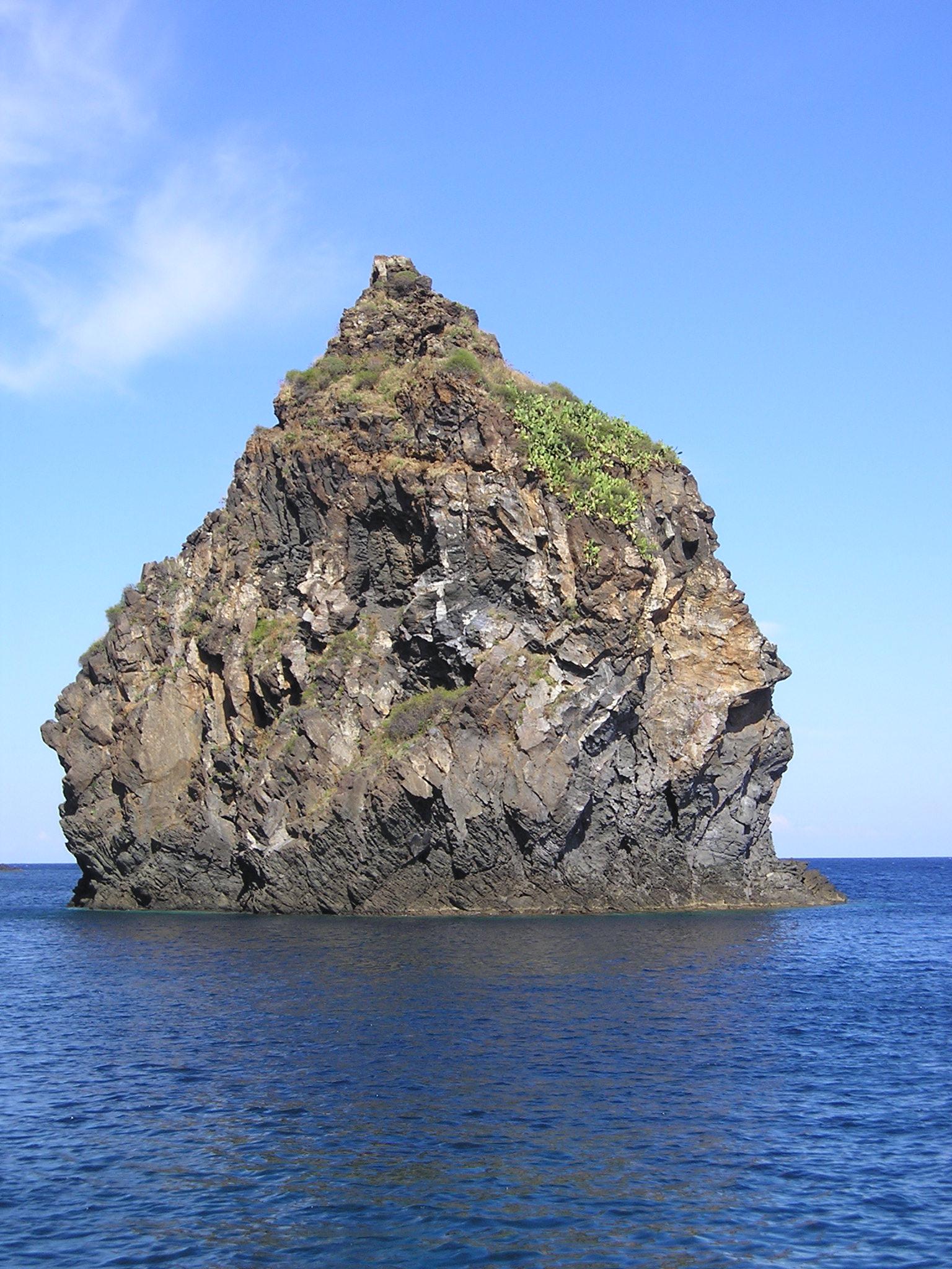 Volcanic faraglione rising from the sea beside Cala Tramontana on Pantelleria